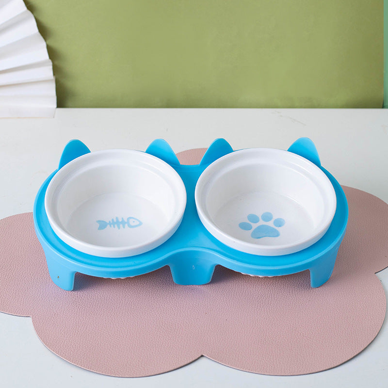 Ceramic cat bowl set featuring a cute design with fish and paw prints in a blue holder