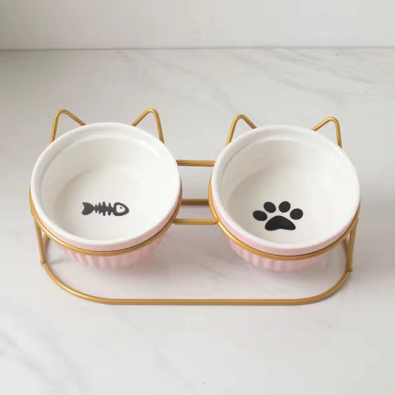 Ceramic cat bowl set with fish and paw prints on stylish gold stand for pet feeding