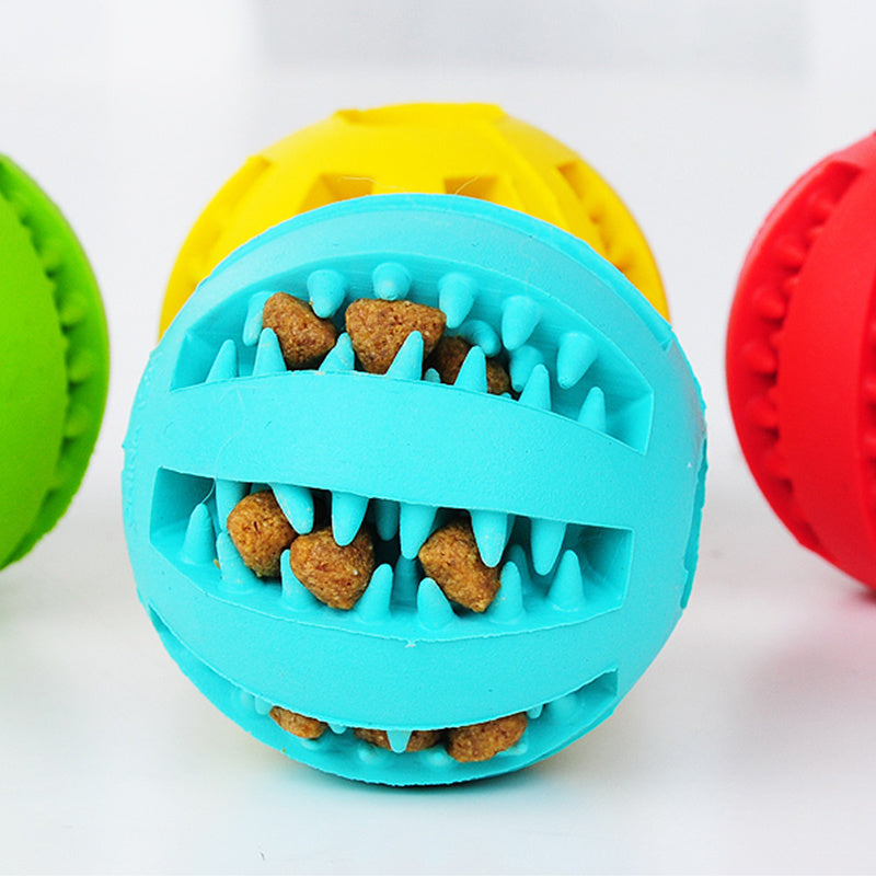 Colorful rubber dog ball toy in blue, yellow, and red with treat-dispensing features for playful pets