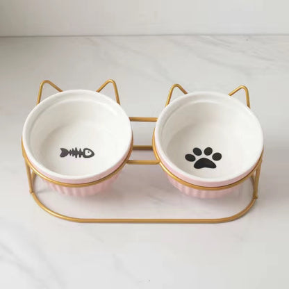 Ceramic cat bowl set with fish and paw prints on stylish gold stand for pet feeding