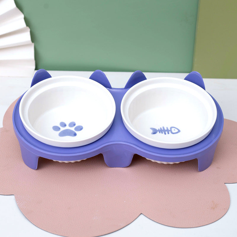 Ceramic cat bowl set with cute paw print and fish design in a purple stand for stylish pet feeding