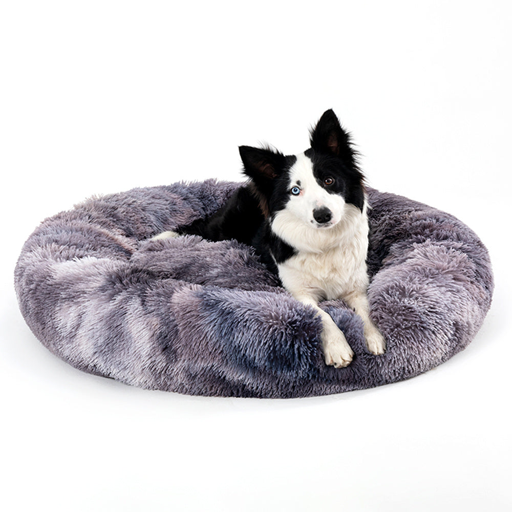 Fluffy donut dog bed in gray with a black and white dog comfortably resting on it