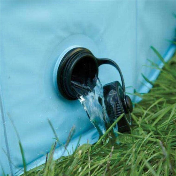 Drain valve of a foldable dog swimming pool releasing water on grass